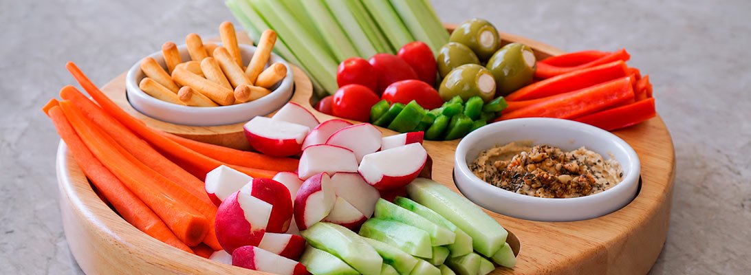 Bandeja con crudites y aceitunas rellenas de queso Gourmet Leon junto a picos de pan y hummus Bandeja con crudites y aceitunas rellenas de queso Gourmet Leon junto a picos de pan y hummus