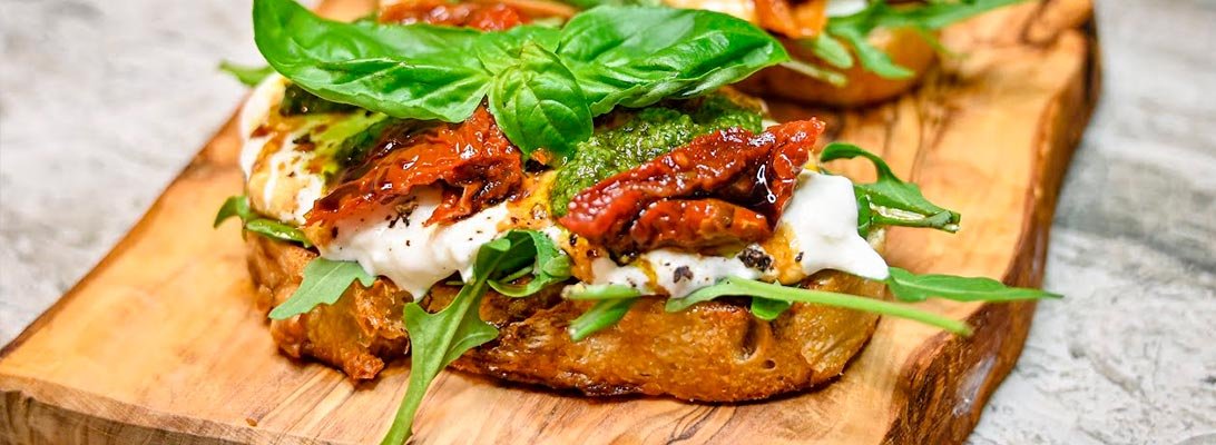 Crostini con pesto y burrata: base para una bruschetta deliciosa