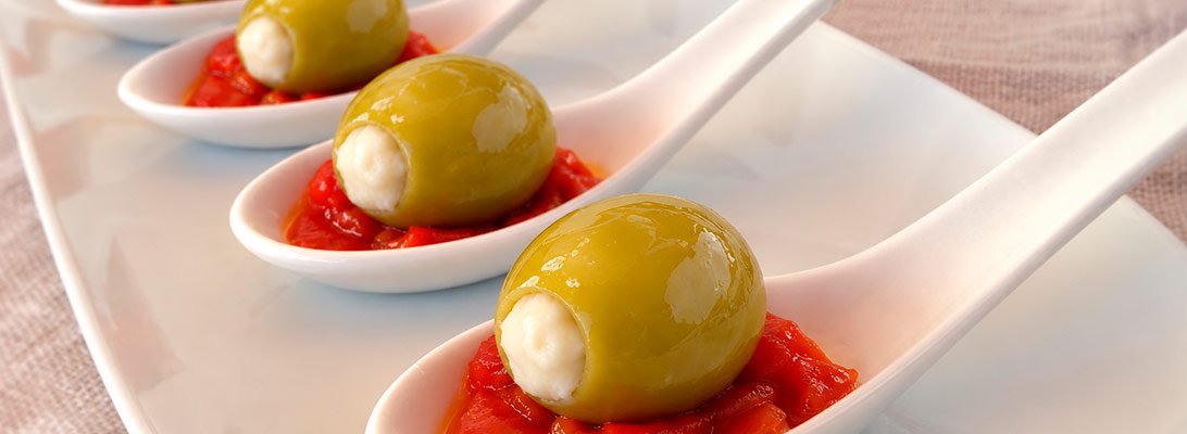 Cucharitas aperitivo con pimiento rojo asado y una aceituna verde grande rellena de queso gourmet leon Cucharitas aperitivo con pimiento rojo asado y una aceituna verde grande rellena de queso gourmet leon